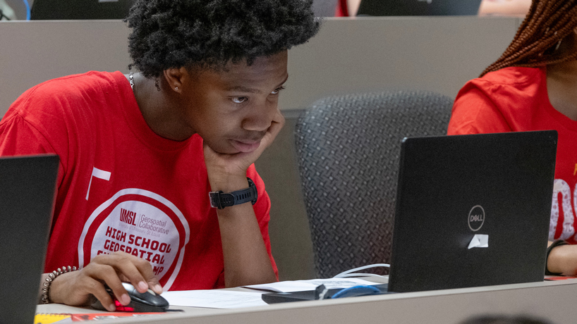Keteyian Cade leans forward to look at his computer screen while solving a problem during UMSL's inaugural Geospatial Summer Camp