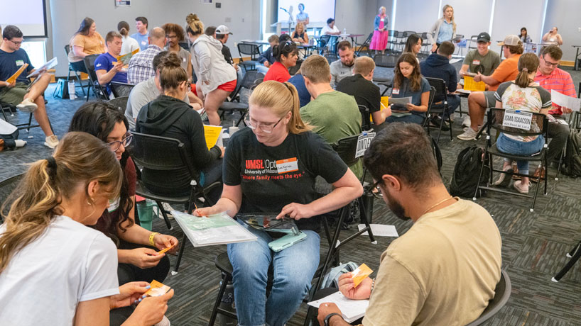 Students discuss their family situations during a poverty simulation on the UMSL campus