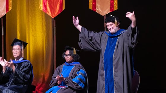 Edward Munn Sanchez, Dean of the University of Missouri-St. Louis Honors College, encourages students to cheer for the honors college during Convocation.