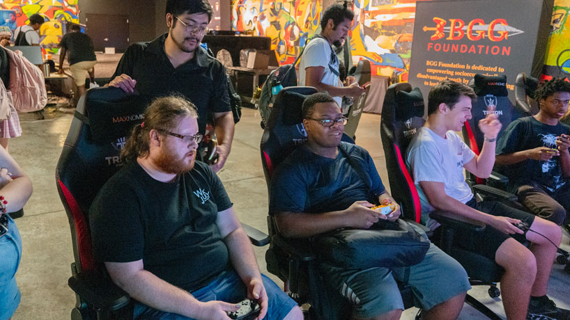 ESports coach Bovey Zhang , Top left, watches University of Missouri-St. Louis students inside the new Esports Arena in the Pilot House for the first Triton Esports Super Smash Brothers Ultimate Tournament on August 24th, 2023. The top 4 players secured an esports scholarship.