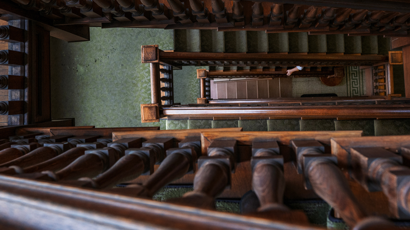 A person holds the handrail as they ascend the stairs in UMSL's Provincial House