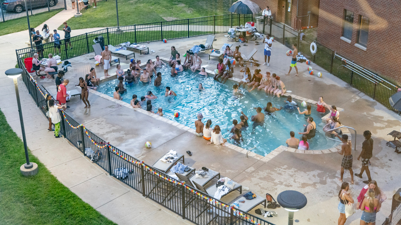 Students hang out in and around the pool outside Oak Hall