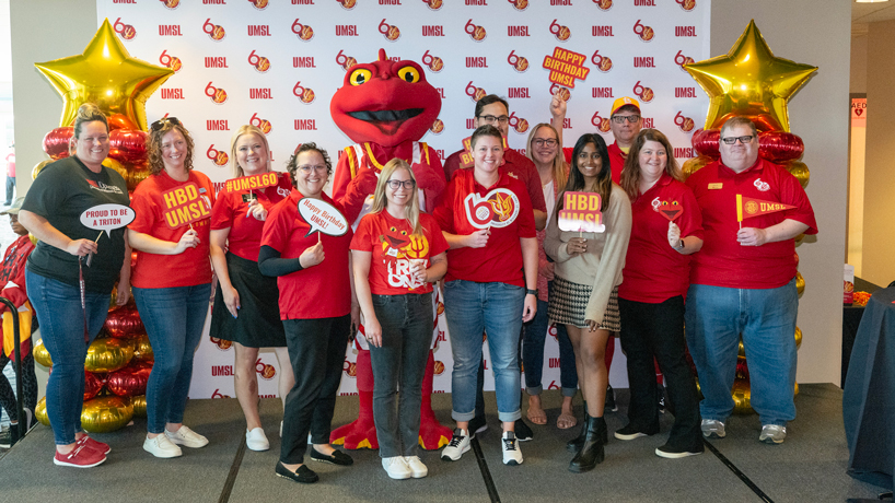 Staff members take photos with Louie during Red & Gold Day