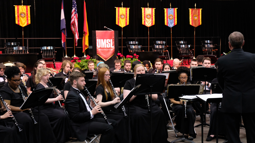 UMSL orchestra performs in front of the commencement stage