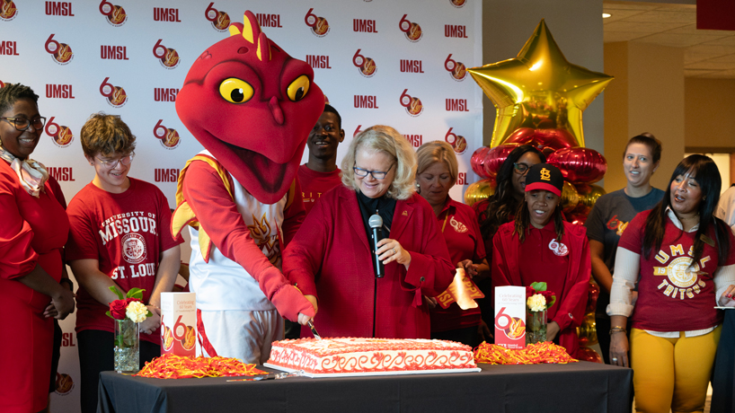 Chancellor Kristin Sobolik and Louie the Triton cut the Cake at the Red & Gold Day Celebration