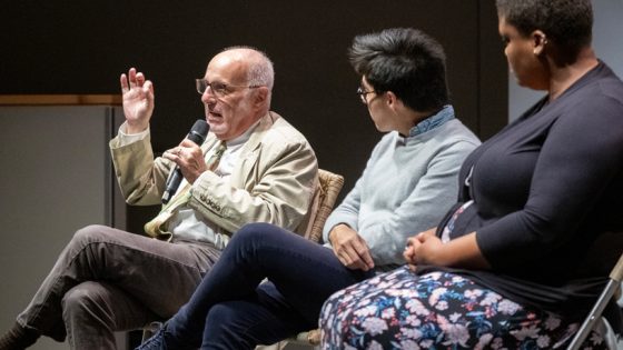 Andrew Hurley speaks into a microphone while seated on stage during the Conservation Forum