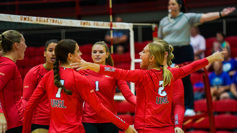 Members of the UMSL volleyball team huddle after a point