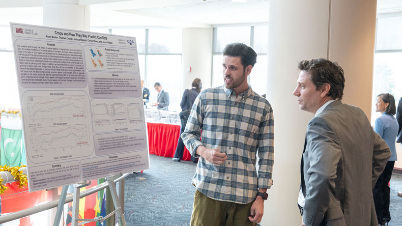 UMSL computer science major Adam Becker discusses his research with UM System General Counsel Mark Menghini during a break in the board of curators meeting