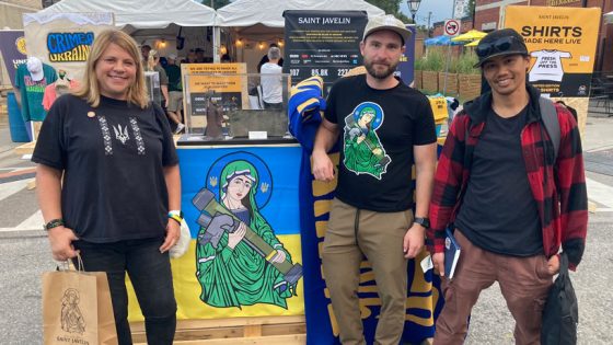 Lara Zwarun stands with an image of "Saint Javelin," Saint Javelin founder Christian Borys and research partner Richard Canevez at the Ukraine Festival in Toronto