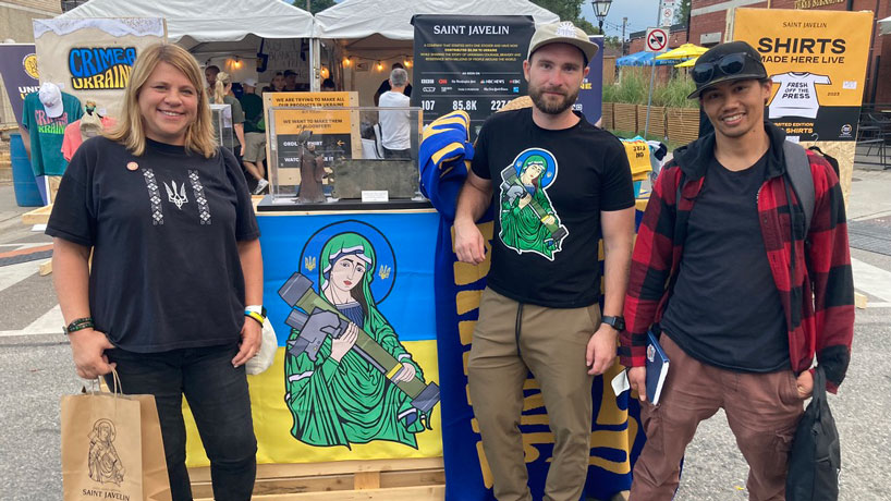 Lara Zwarun stands with an image of "Saint Javelin," Saint Javelin founder Christian Borys and research partner Richard Canevez at the Ukraine Festival in Toronto 