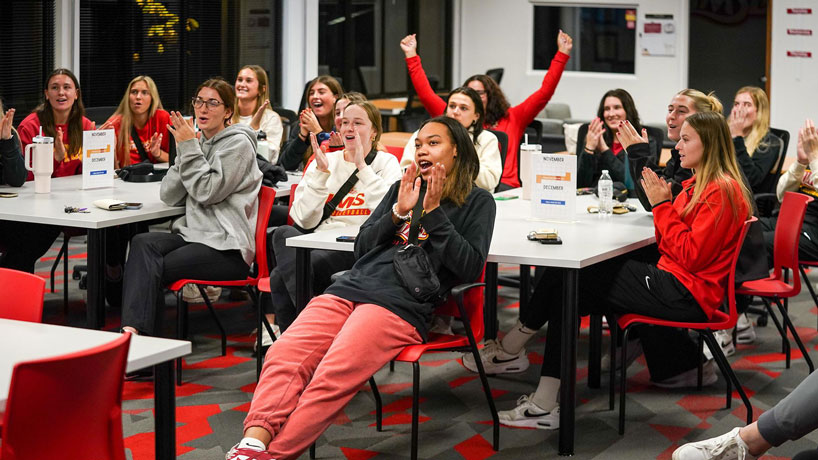 UMSL volleyball players react with applause during the NCAA Division II Volleyball Championship selection show after learning they received the top seed in the Midwest Region Tournament