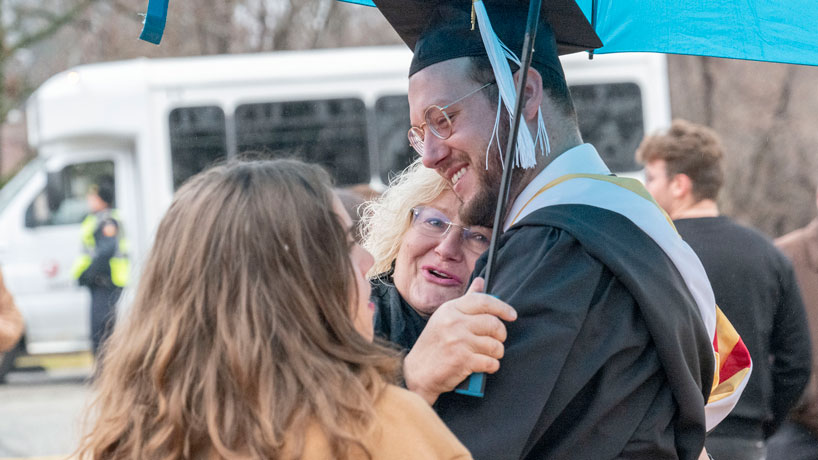 graduate hugs a family member