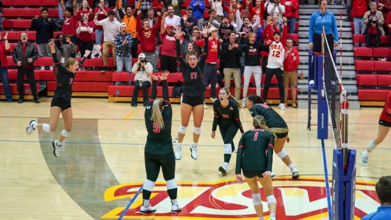 The UMSL volleyball team celebrates the clinching point in their Midwest Region Championship victory over Ferris State as the crowd erupts behind them