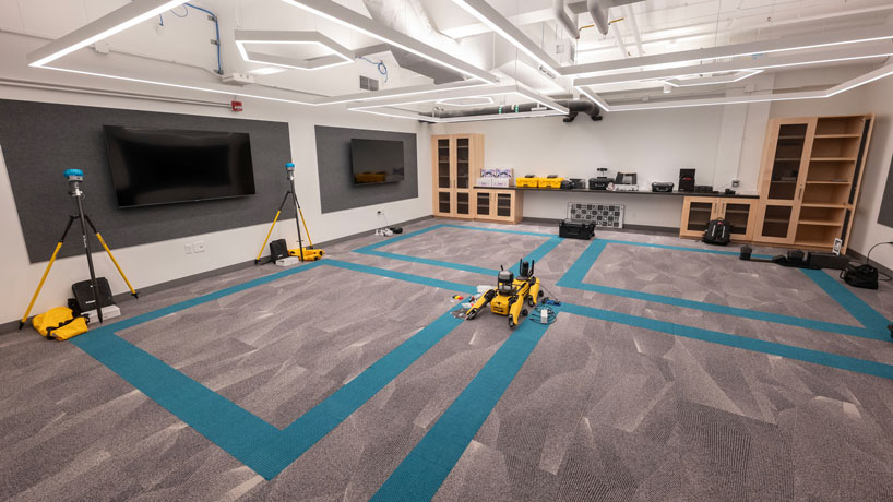 UMSL's new virtual reality lab, with monitors on the walls, and Spot, the agile mobile robot, lying on the floor in the center of the room