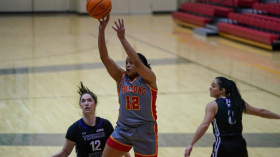 UMSL women's basketball player Amaya Blake releases a jump shot with two Truman State defenders watching