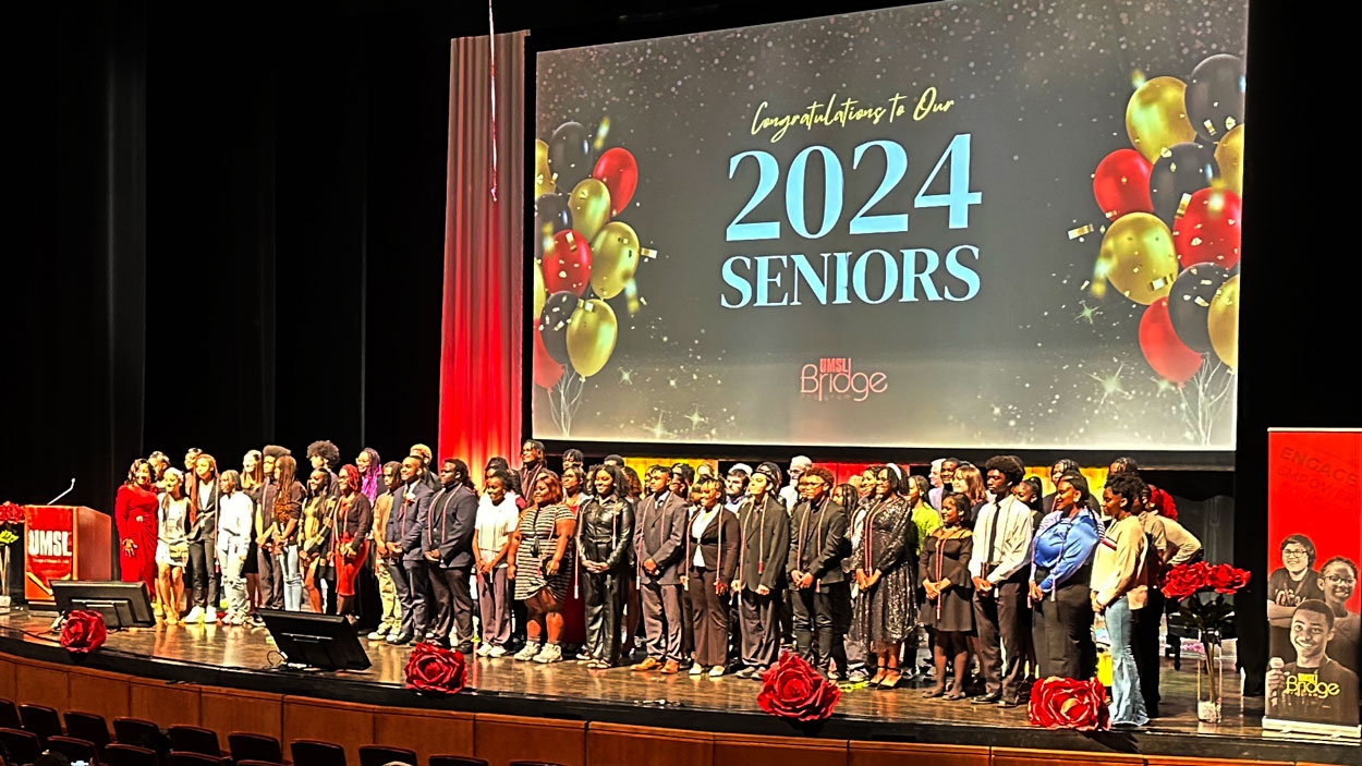 The 2024 graduating class of the UMSL Bridge Program Cigna Saturday Academy on stage at the Blanche M. Touhill Performing Arts Center