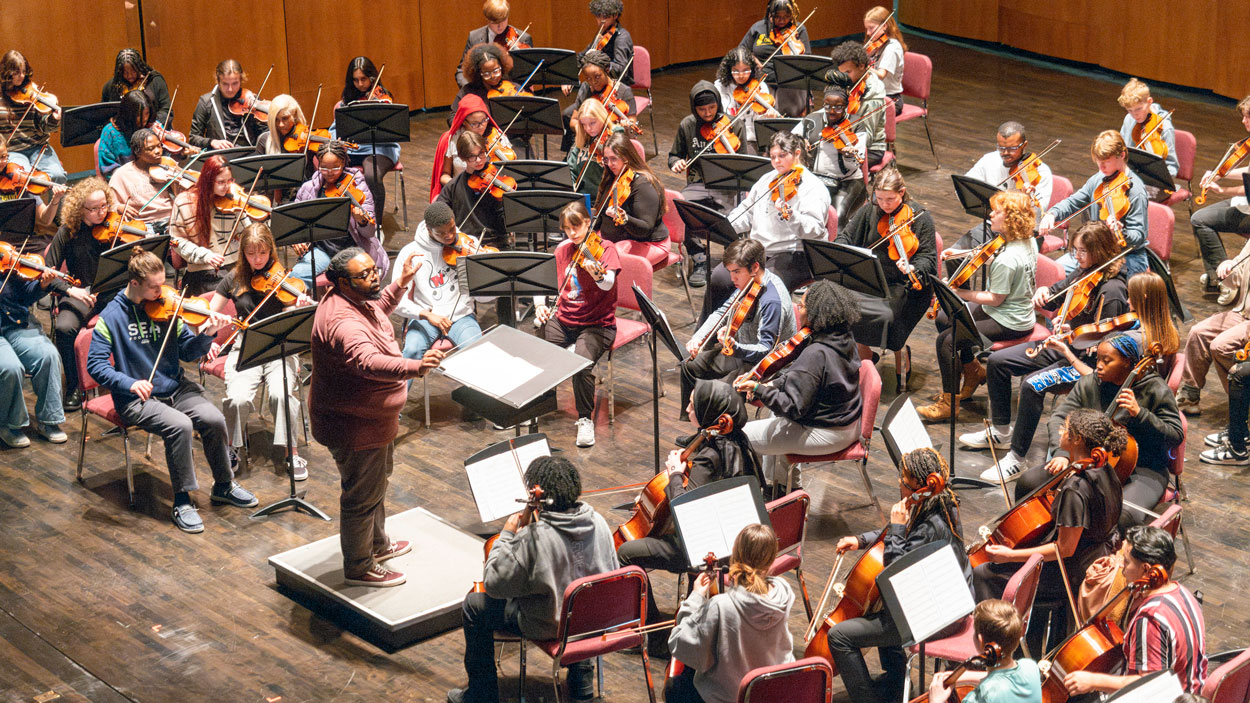 Webster Groves School District music educator, Andrew Pulliam, directs the orchestra 