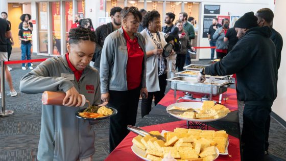 Eboni Valentine, the marketing and communications coordinator in the College of Business Administration, adds sauce to her plate of soul food at the Black History Month kickoff event on the third floor of the Millennium Student Center