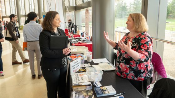 Student speaks with representative from Federal Reserve Bank of St. Louis