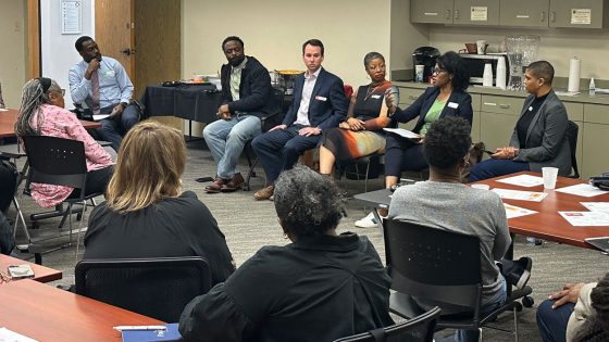 STLAAN Director Stefani Weeden-Smith speaking during a panel discussion as the audience and fellow panelists listen