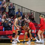 UMSL women's basketball players swarm teammate Jalysa Stokes in front of cheering fans after she sank a game-winning shot as time expired against Indianapolis