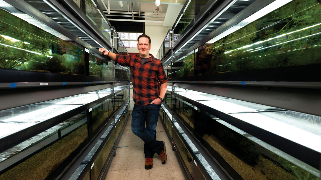 Michi Tobler stands among the fish tanks in his lab in the Research Building