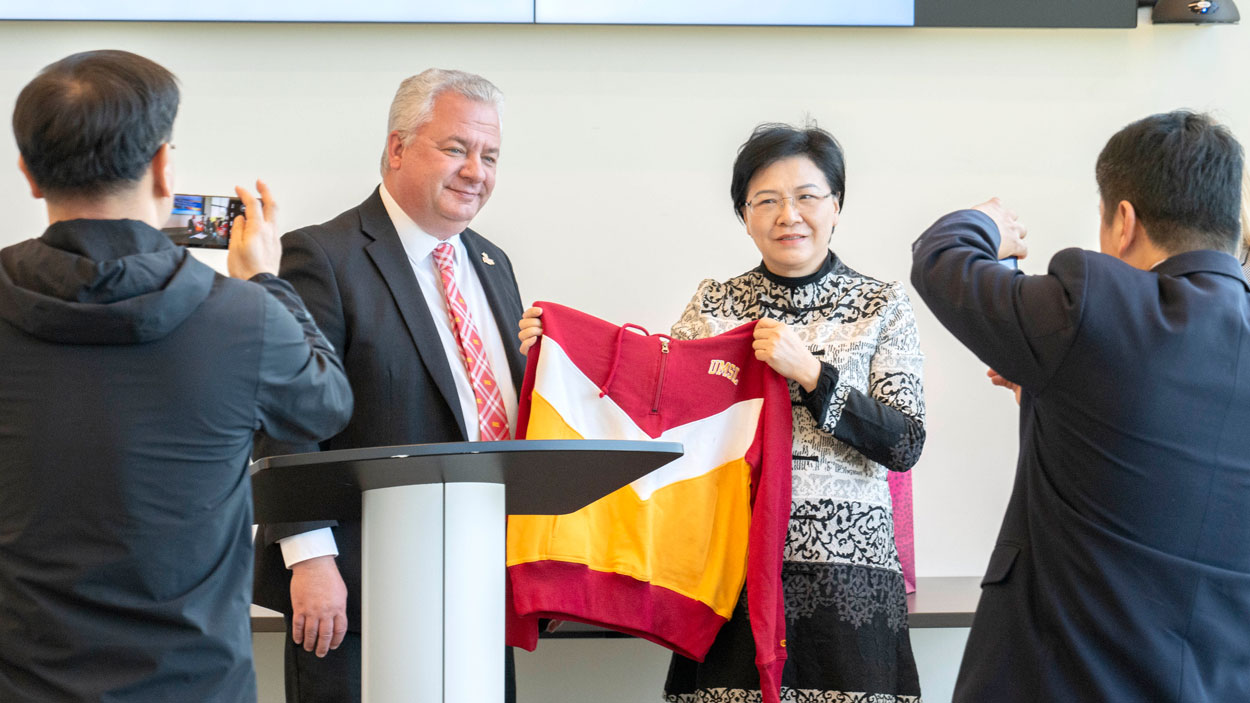 Steven J. Berberich, the provost and vice chancellor for academic affairs at the University of Missouri–St. Louis, presents an UMSL sweatshirt to Han Liming, who was visiting St. Louis over the weekend as part of a delegation from its sister city in Nanjing, China.