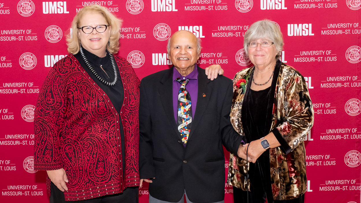 Chancellor Kristin Sobolik, Surendra Gupta and Karen Gupta in front of an UMSL-logoed backdrop