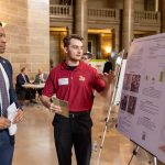 Biology student Jesse Laseter speaks to State Sen. Brian Williams about his research during UM System Undergraduate Research Day at the Capitol