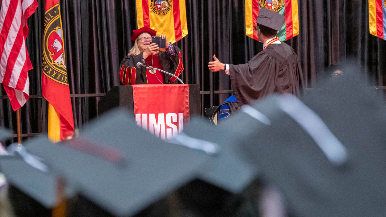 Chancellor Kristin Sobolik takes a photo of UMSL alum Alex Kerford before he welcomed the new alumni