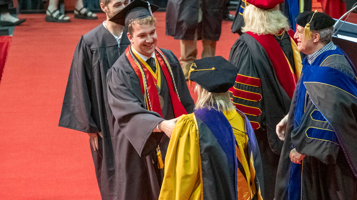 Biology graduate Alexander Entwhistle, who last fall received the Remington R. Williams Award from the University of Missouri System Board of Curators, shakes hands with Curator Julie Brncic.