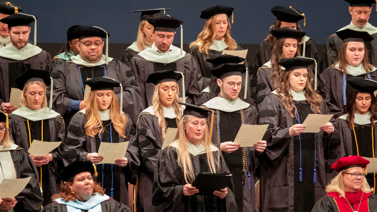 Dr. Anne Ream (center) joins new graduates of the College of Optometry in reciting The Optometric Oath