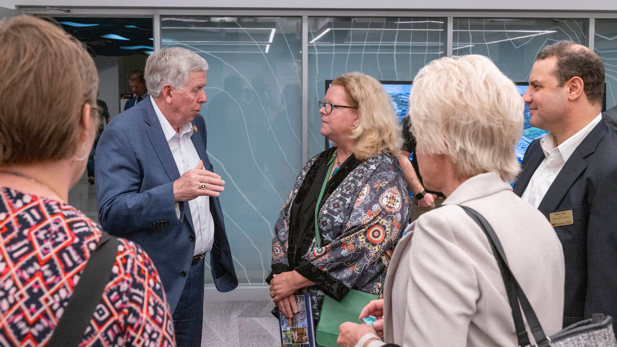 Missouri Governor Mike Parson speaks to UMSL Chancellor Kristin Sobolik, Geospatial Collaborative Director Reda Amer and others in the Geospatial Advanced Technology Lab in Benton Hall