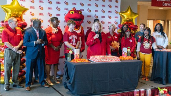 Chancellor Kristin Sobolik speaks, surrounded by alumni, students, faculty and staff, during a Red and Gold Day celebration in the Millennium Student Center as the UMSL community gathers to mark the 60th anniversary of the university's founding