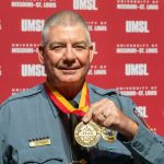 UMSL Chief of Police Dan Freet holds up the Chancellor's Medal he received at Friday's State of the University Address