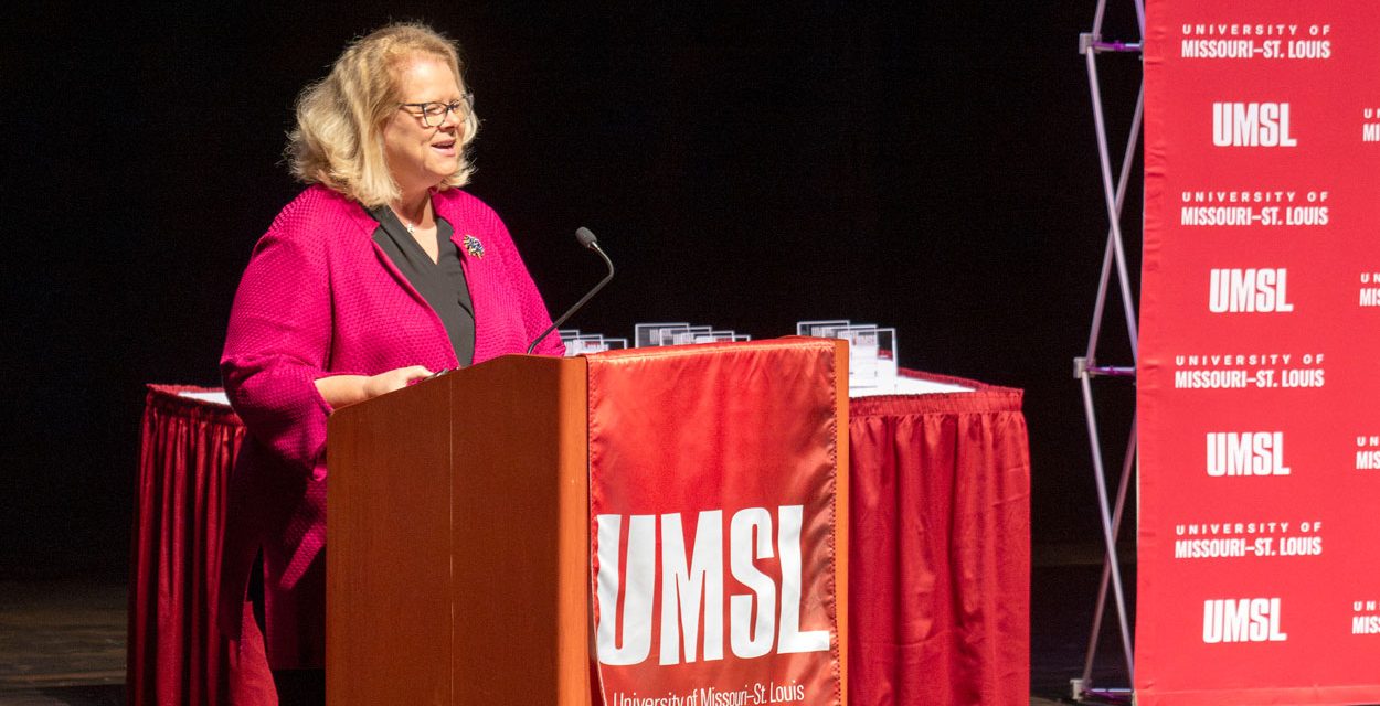 Chancellor Kristin Sobolik speaking from a lectern on stage in the Blanche M. Touhill Performing Arts Center