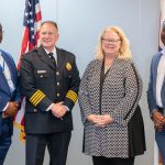 (From left) St. Louis Metropolitan Police Department Academy Director Clarence Hines, St. Louis Metropolitan Police Commissionr Robert J. Tracy, University of Missouri–St. Louis Chancellor Kristin Sobolik and Vice Chancellor for Strategic Enrollment Reggie Hill stand in front of flags of the United States and Missouri