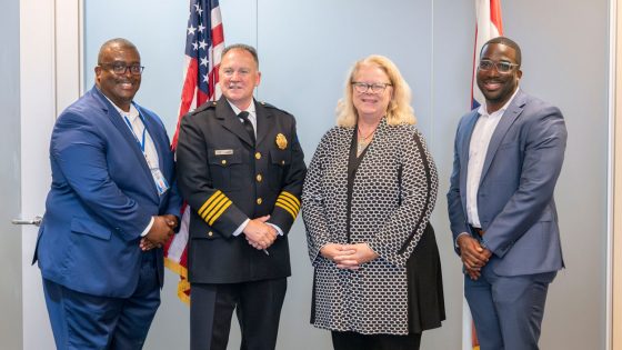 (From left) St. Louis Metropolitan Police Department Academy Director Clarence Hines, St. Louis Metropolitan Police Commissionr Robert J. Tracy, University of Missouri–St. Louis Chancellor Kristin Sobolik and Vice Chancellor for Strategic Enrollment Reggie Hill stand in front of flags of the United States and Missouri