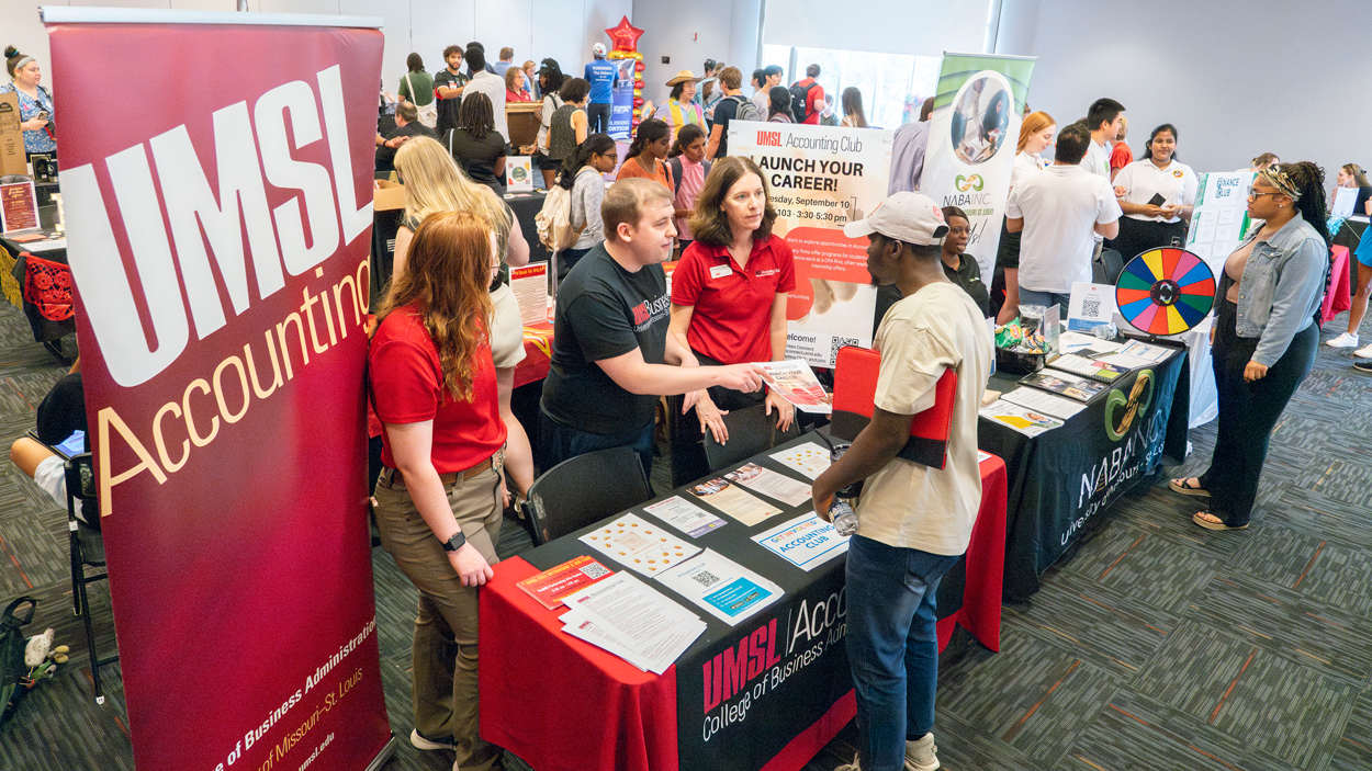 Members of the UMSL Accounting Club, including master's students Angela Truesdale and Thomas Fabry and Associate Teaching Professor in Accounting Marcia Countryman, speak with students