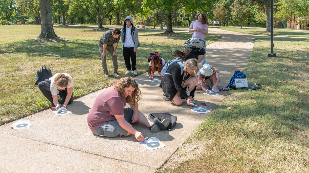 UMSL astronomy students observe the path of the sun last week outside University Libraries on North Campus during a class led by Mohi Saki