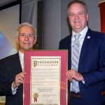 St. Louis County Executive Dr. Sam Page (right) presents Michael Cosmopoulos with a proclamation commemorating the 30th anniversary of the Greek Studies Professorship at UMSL