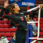 Addison Voorhees leaps to swing at a volleyball