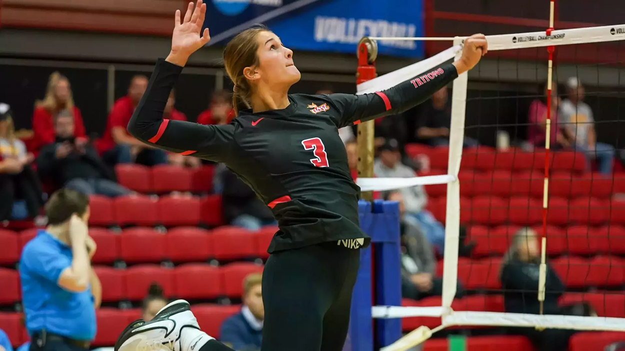 Addison Voorhees leaps to swing at a volleyball