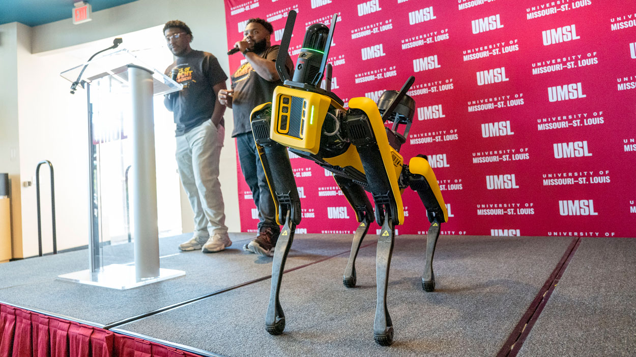 Elijah McCoy (center) and Jalen Walker-Wright from the Office of Student Involvement help kick off the official launch of an initiative to help name UMSL Geospatial Collaborative's agile mobile robotic dog on Tuesday afternoon at The Nosh.