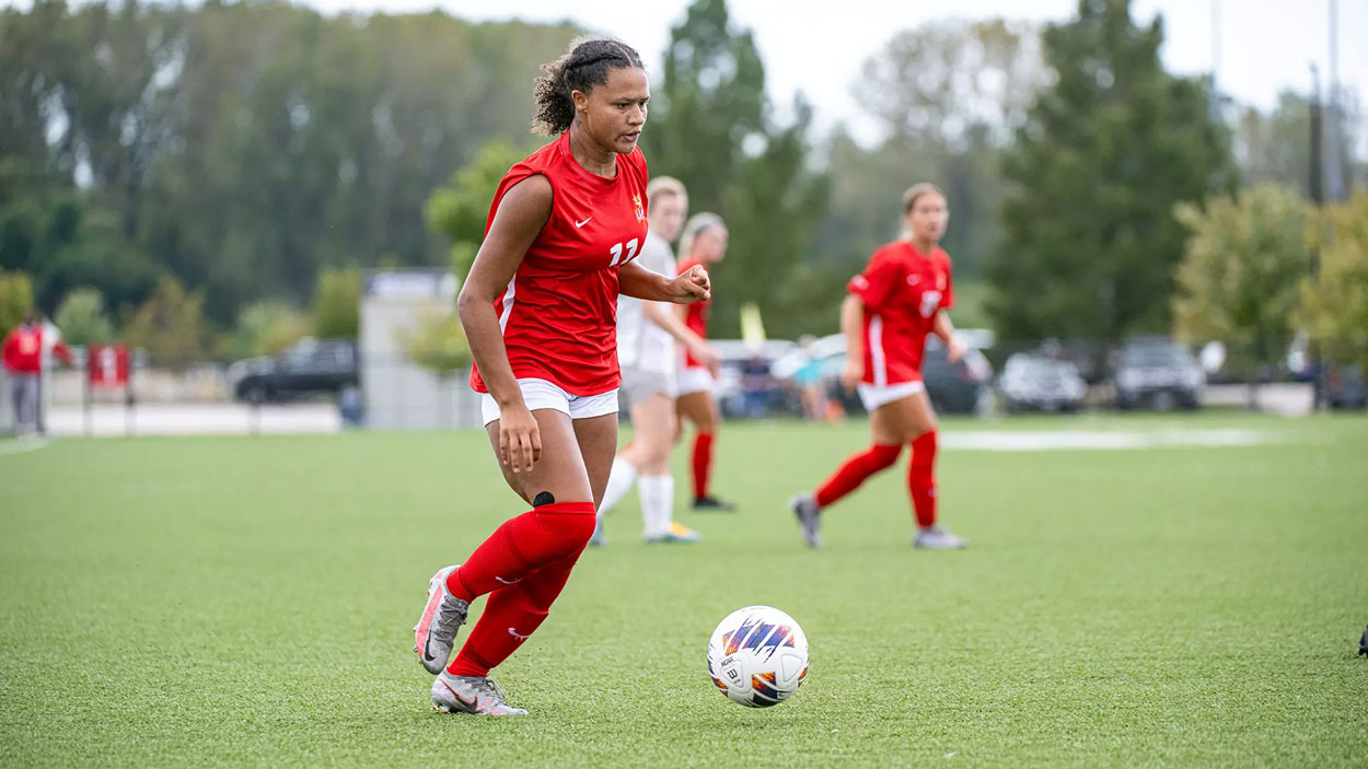 Women's soccer player Jada Holloman dribbles the ball