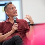 José Antonio Bowen sitting and holding a microphone