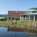 Students sit by pond