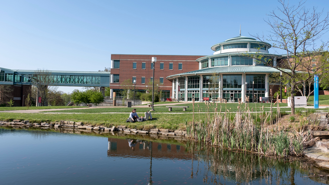 Students sit by pond