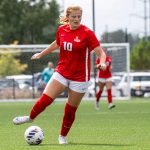 Senior midfielder Kayley Judy dribbles a soccer ball in the open field