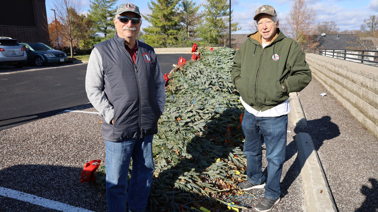 Howard Berliner and Irwin Loiterstein stand next to a Christmas tree